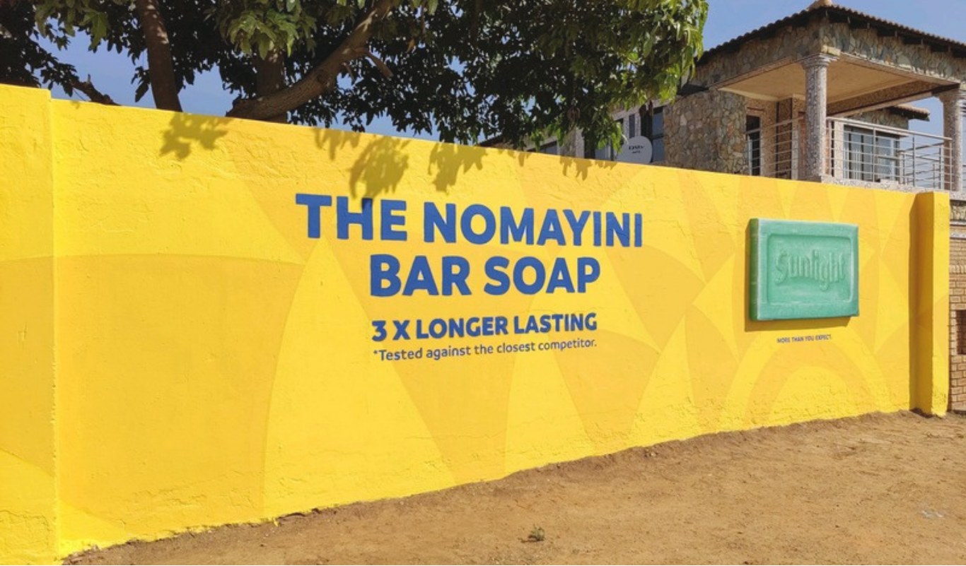Bold hand-painted advertising mural on a township wall